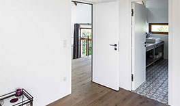 Wohnung 1 - Die Wände des Schlafzimmers sind oberhalb verglast, dadurch ist der Dachstuhl in der gesamten Wohnung sichtbar - Tina Assmann - Innenarchitektur - München